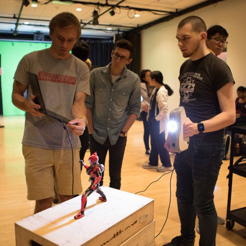 Students working a robot and laptop