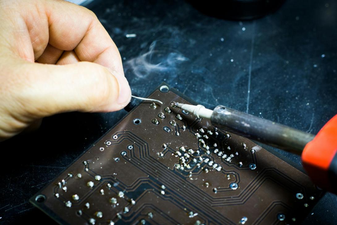 close up of someone soldering a board